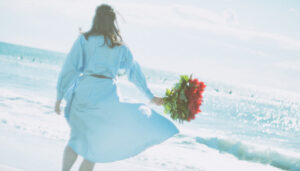 海を歩く花束を持つ女性